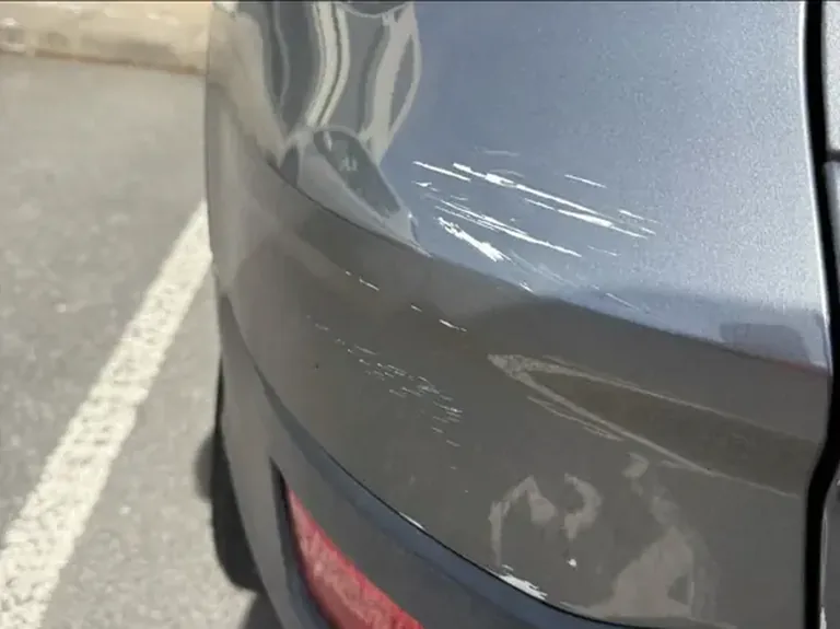 Close-up of a scuffed rear bumper before repair